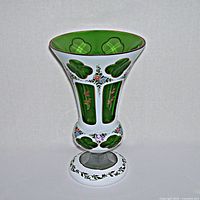 Front view of vintage green cut to clear glass vase with white enamel and gold floral decoration