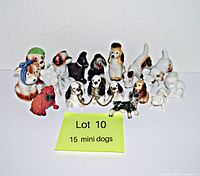 Front view of 15 vintage miniature dog figurines standing arranged in rows on white background with lot sign