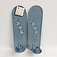 Pair of vintage blue tin wall candle sconces decorated with handpainted rose flowers, showing overall look and condition.