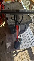 Front view of Joe Blow bicycle pump showing T-shaped handle, red metal barrel and black foot base