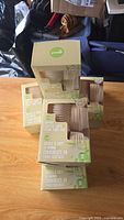 Five boxed packs of bamboo coffee cups with lids stacked for display.