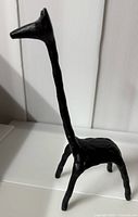 Side angled view of the black cast iron giraffe sculpture with matte texture.