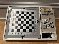 Silver Designer Chess Challenger electronic chess board with black and white grid, coordinate markings, and control panel on the right side