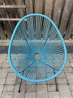 Front view of blue Acapulco style woven rope chair showing fan-like pattern and circular open center.