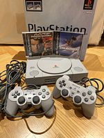 Console with controllers, games and box in background