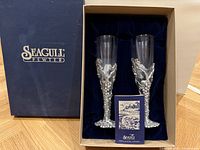 Box of two brand new Seagull Pewter flutes featuring handblown glass and detailed grapevine pewter bases with velvet lining.