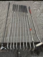 Full view of all golf clubs laid out, showing club grips and shafts.