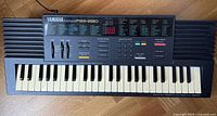Full view of Yamaha PortaSound PSS-280 electronic keyboard showing 49 keys with noticeable yellowing.
