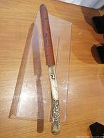 Full view of the page turner showing wood blade with flower design and bone handle