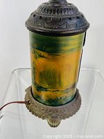 Side view of the antique light showing decorative metal top and bottom with scenic painted glass shade depicting Niagara Falls.