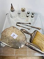 Full view of the vanity set including the hand mirror, hairbrush, tweezers, pick, glass shakers and mini salt and pepper shakers.