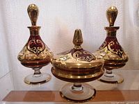 Front view showing one dresser jar with lid and two matching perfume bottles placed symmetrically.