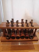 Front view of wooden rack holding 12 pipes
