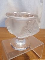 Front view of frosted and clear Lalique crystal holder with lion head design.
