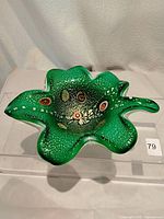 Top view of the green cased Murano art glass leaf shaped sculpture showing embedded millefiori floral patterns.