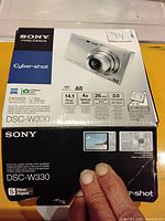 Original Sony DSC-W330 Cyber-shot camera box showing model, megapixels, zoom, lens, and LCD specs.