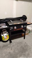 Front view of assembled Blackstone tabletop griddle on cart with propane tank attached