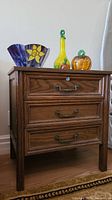 Front view of the solid wood chest of drawers showing the three drawers, metal pulls, and keyhole in top drawer.