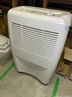 Front view of white Garrison dehumidifier with ventilation on front and control panel on top.