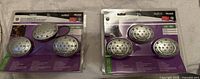 Photo of two unopened packs of Westek LED accent lighting, each containing 3 silver oval LED lights on purple and white cardboard backing in blister packaging.