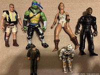 Front view of 6 action figures arranged upright including GI Joe knockoff Arctic Cyborg, Tonka figure, Masked Rider, Robert Muldoon, Teela, and TMNT Leonardo