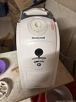 Front view of white Honeywell humidifier showing air vent, digital display and control buttons on table.