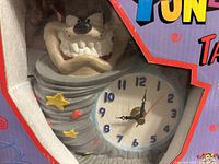 Close-up of the hand-painted Taz in tornado-shaped ceramic quartz clock inside packaging.