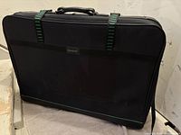 Front view of the black rectangular Samboro suitcase with green-striped straps and top handle, showing overall condition and design.