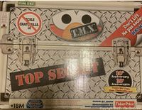 Photo of TMX Tickle Me Elmo 10th Anniversary original packaging box with metal plate graphic and Sesame Street branding