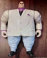 Front view of ToyBiz Kingpin figure showing off-white jacket, purple shirt details, light blue pants, and black shoes on wooden floor.