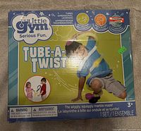 Box of The Little Gym Tube-A-Twist with a child playing illustration on front, highlighting its features as a wiggly, squiggly marble maze toy for children 3+