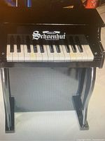 Front view of the vintage Schoenhut miniature piano showing the keyboard and brand name on the front panel.