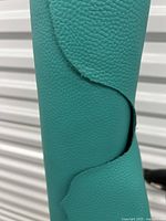 Close-up of teal leather showing grain and texture.