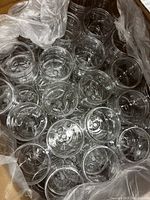 Top-down view showing multiple clear plastic jars packed together in a box.