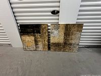 Front view of two square abstract canvas paintings showing textured block style art with brown and dark shades.