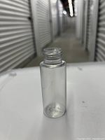 Single empty clear plastic 60ml bottle standing upright, showing size and shape