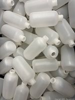 Multiple frosted semi-translucent 8oz Boston round bottles shown piled together without caps.