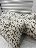 Three brand new rectangular lumbar pillows made from traditional African mudcloth, featuring distinctive black and white geometric tribal patterns.
