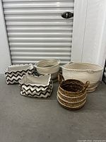 Front view of five baskets arranged on floor showing various sizes and patterns including chevron and stripes