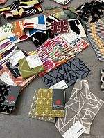 Overhead photo showing a variety of colorful fabric swatches with different patterns and designs scattered on the floor.