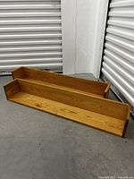 Two solid oak wood floating shelves shown on the floor, displaying front and side views to highlight construction and finish.