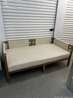 Full view of daybed showing solid oak frame and light vinyl cushions.