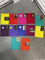 Top-down view of all 13 Phaidon softcover art books showing their colorful covers with small classic artwork thumbnails and Phaidon branding.