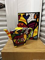 Front view of the teapot with original colorful matching box behind