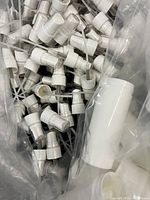 Photo showing black 18mm sprayers with white spray tubes inside a container.
