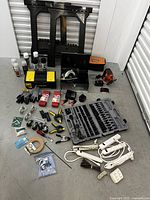 Overview of the variety of tools including socket set case, toolbox, clamps, gloves, power tools, extension cords, and hardware supplies.