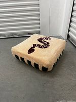 Angle view highlighting plush tufted surface and snake design