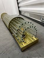 Close-up of one end showing rectangular brass mounting plate and fluted glass rods.