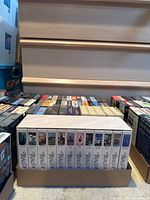 Two boxes filled with assorted VHS tapes including a white boxed complete David Attenborough The Trials of Life series set.