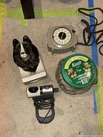 Photo showing all four items: Sheltie dog ceramic piece, vintage Time-All timer, Kraft cookie jar, and Logitech USB webcam with USB plug and cable.